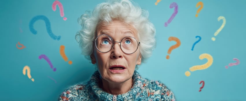 The elderly woman looking up with a thoughtful expression and question marks around her. photo
