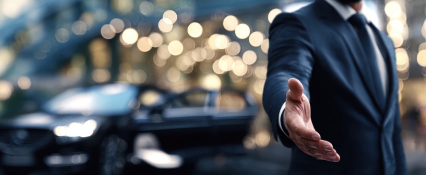 The businessman extending a hand in a luxurious urban setting with a car. photo