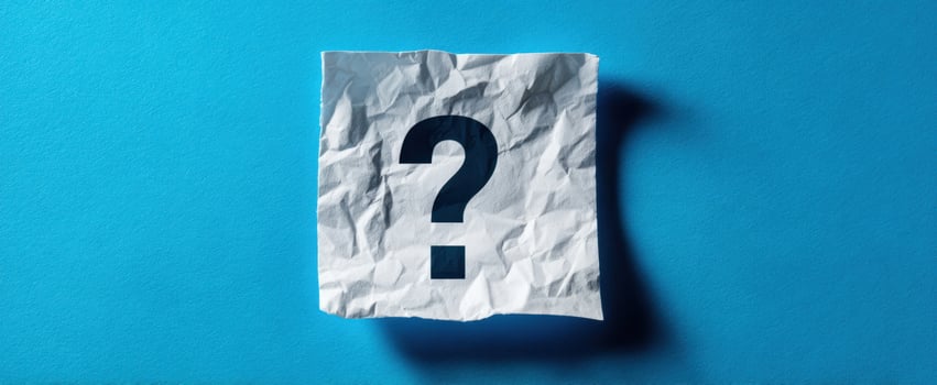 The crumpled paper with a question mark on a blue background photo
