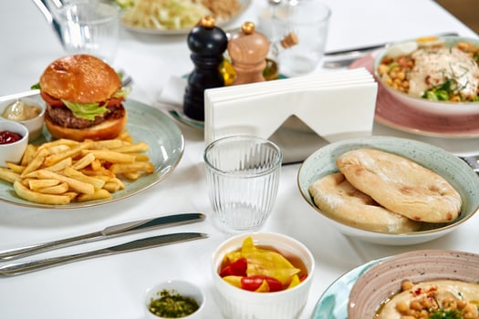 An Inviting Table Set with a Variety of Delectable Dishes Including Burgers, Fries, and Fresh Salads Ready for a Satisfying Meal Experience photo
