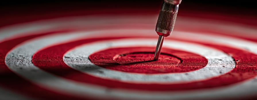 The dart striking the center of a vibrant red and white target. photo