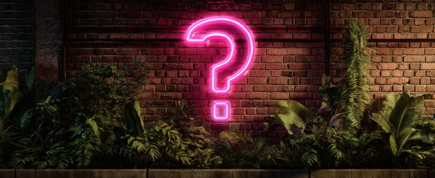 The glowing neon question mark shines against the textured brick wall. photo