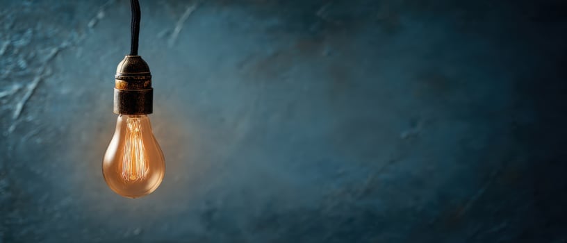 The vintage light bulb hanging against a textured dark blue background. photo