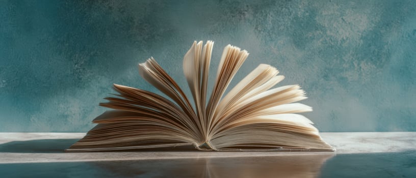 The open book revealing pages under soft, atmospheric light on a desk. photo