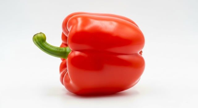 Vibrant Red Bell Pepper with Green Stem on White Background Studio Shot. photo