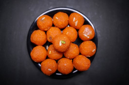 A Indian traditional sweet Laddu served in a black bowl photo
