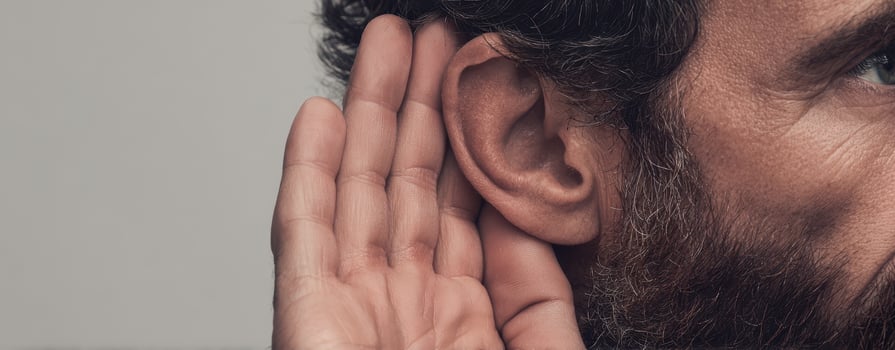 The man listening intently with hand cupped to ear in a thoughtful gesture. photo