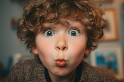 A young boy with curly hair making a funny face photo