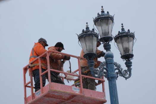 Two men on a lift working on a street light photo