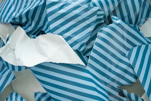 Torn striped wrapping paper in close-up as symbol of seasonal waste and unnecessary paper overuse photo