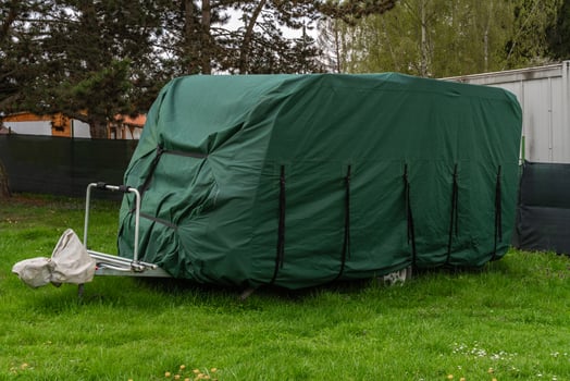 Green protective cover on parked travel trailer in Nova Zivohost campsite, Czech Republic photo