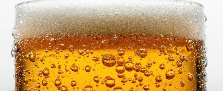 The frothy beer glass with bubbles and golden amber color. photo