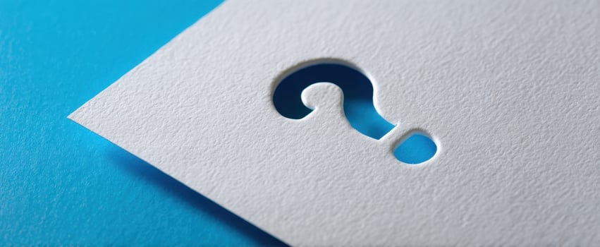 The Question Mark Cutout on Textured White Paper Against a Blue Background photo