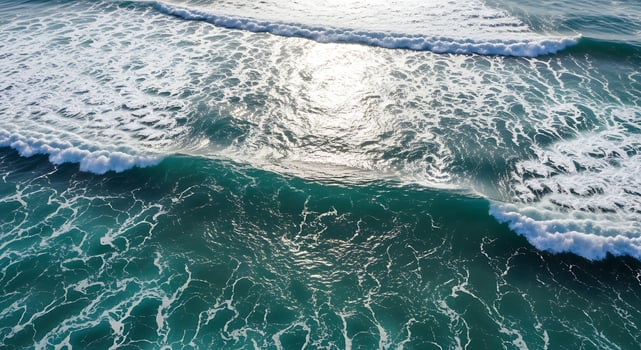 Aerial view of turquoise ocean waves with sunlight reflecting on the surface photo