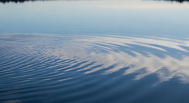 Calm water surface reflecting the sky and clouds photo