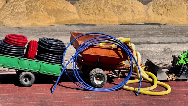 A lively scene with hoses and carts, displaying a mix of construction and industrial materials in use photo