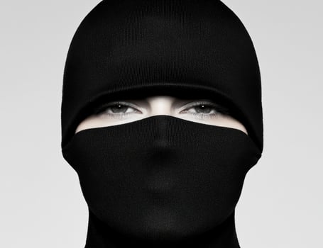 Mysterious woman in black balaclava with intense gaze photo
