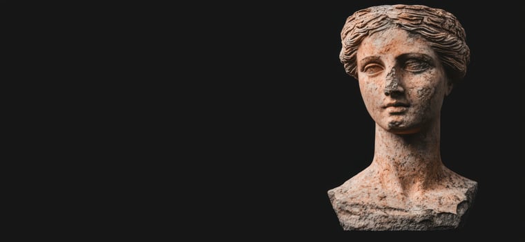 Ancient weathered sculpture of a woman against black background photo