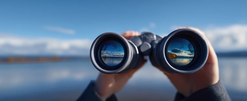 The binoculars revealing stunning landscapes and serene waters under a clear sky. photo