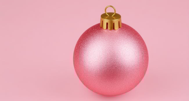 Pink christmas ornament on pink background, holiday decoration photo