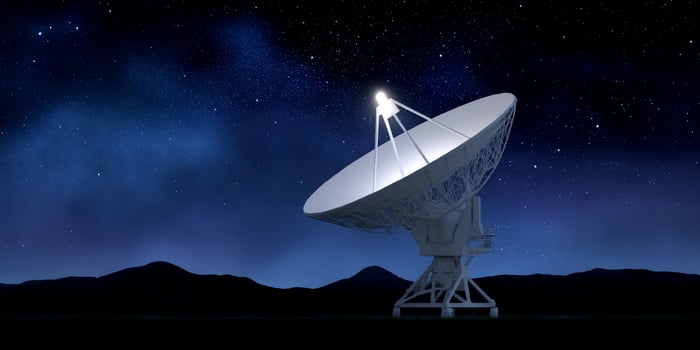 A radio telescope observing signals with a dark night starry sky background photo