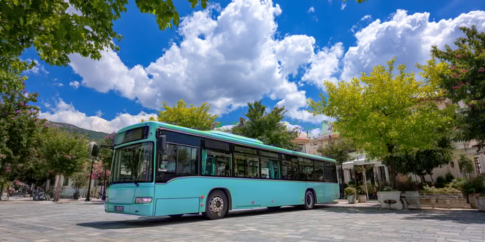 Blue passenger bus with scenic view of blue sky and green trees, travel transport photo