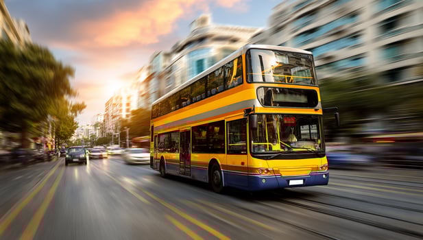 A double decker bus driving down a city street photo