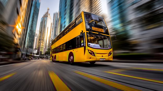 Double decker bus streaks down city street, buildings blur, yellow stripes on road photo