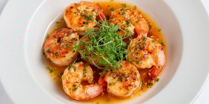 A plate of shrimp with sauce and garnish photo