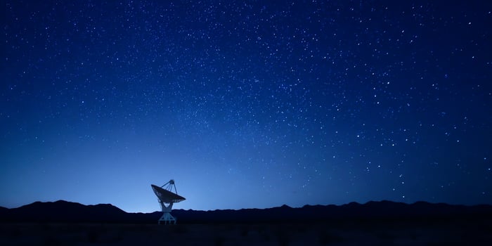 Radio antenna on desert floor under a clear, starlit night sky photo