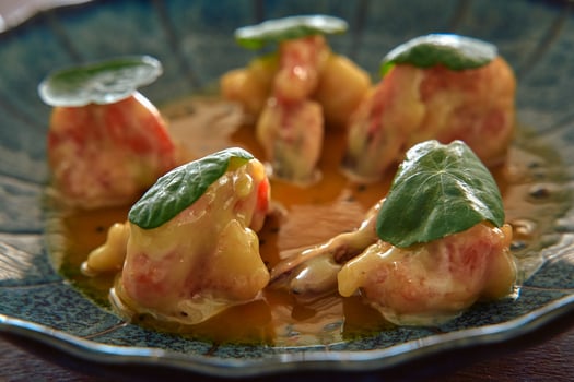 Elegant Dish of Delicate Dumplings Topped with Fresh Herbs and Rich Sauce, Showcasing Gourmet Culinary Artistry and Flavorful Presentation photo