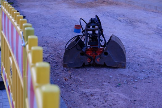 Yellow Plastic Construction Fence with Abandoned Metal Excavator Bucket photo
