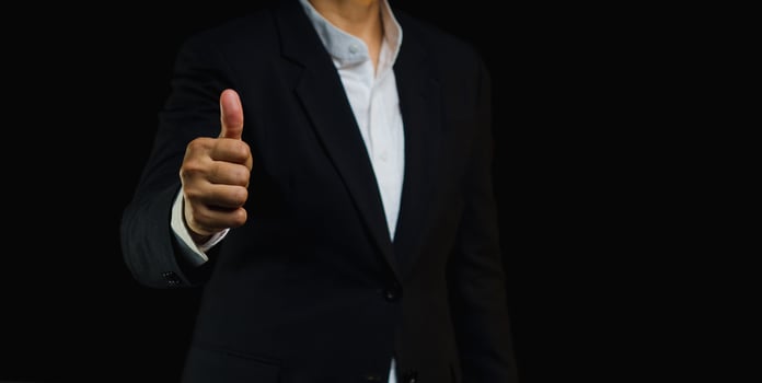 Close-up of a fingers gives the client satisfaction thumbs up for the best excellent services. photo