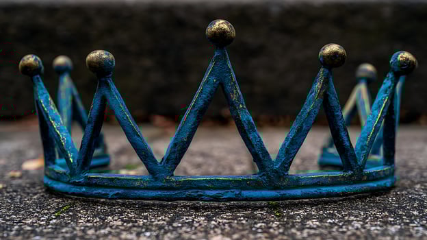 Majestic Blue Crown with Golden Accents Sits on Textured Ground. photo