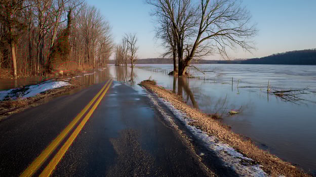 Flooded Road Through Snowy Woods During Spring Melt. photo