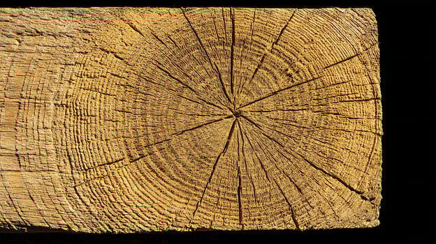 Close up of a cracked weathered wooden beam with distinct grain patterns. photo