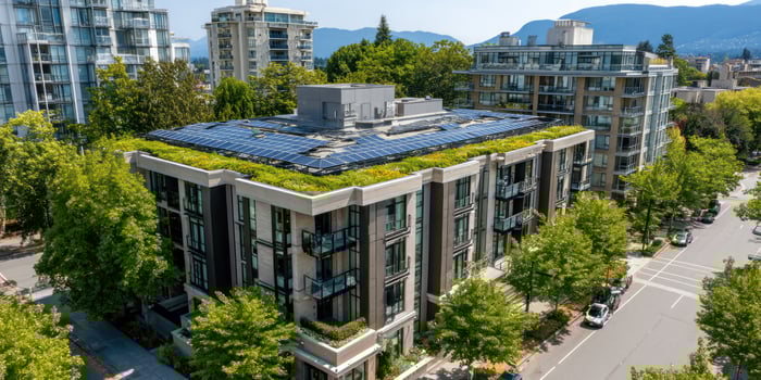 Green roof apartment with solar panels, trees, cars, and buildings. Use real estate photo