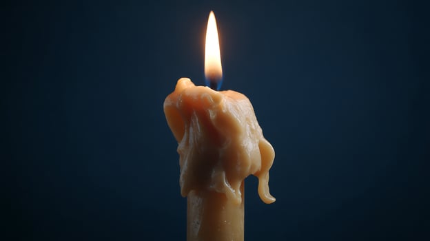 Close Up of a Dripping Candle Flame Illuminating the Darkness. photo