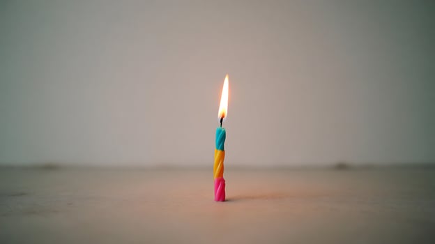 Single Lit Birthday Candle With Colorful Stripes, Ready for a Wish. photo