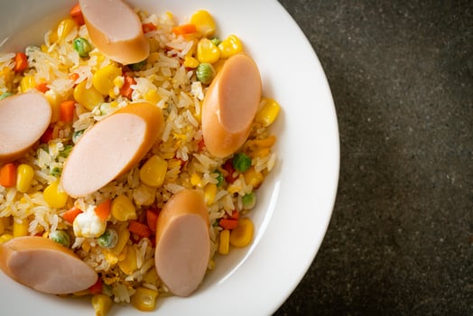 fried rice with sausage and mixed vegetable on dark background photo
