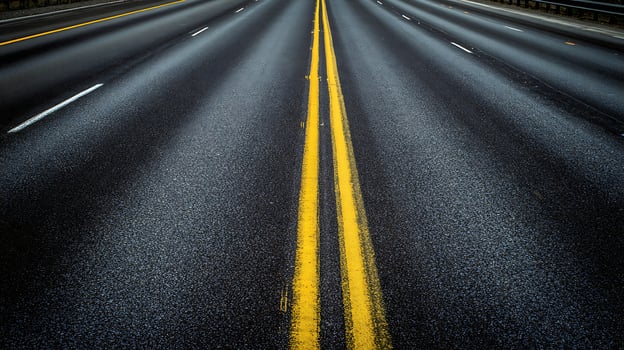 Wet Asphalt Highway Lanes with Bright Yellow Lines Reflecting Light. photo
