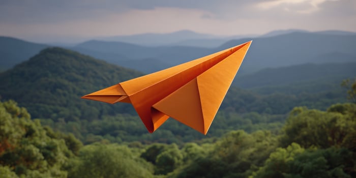 Paper airplane soars above mountain forest backdrop, symbol of dreams, travel photo