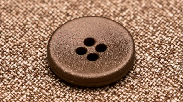 Close up of a brown button on textured fabric. photo