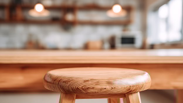 Rustic wooden stool in a softly lit, modern kitchen setting. photo