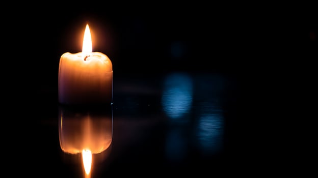Serene Candle Flame Reflecting Warmth on Dark Water. photo