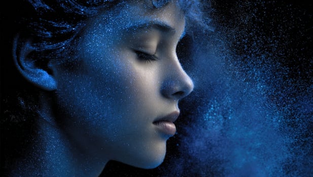 Profile of a woman with blue powder, eyes closed on a black studio background photo