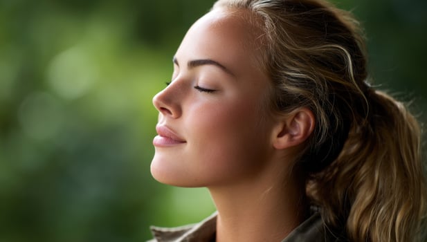Woman breathing deeply in nature, with peaceful expression, for wellness ads photo