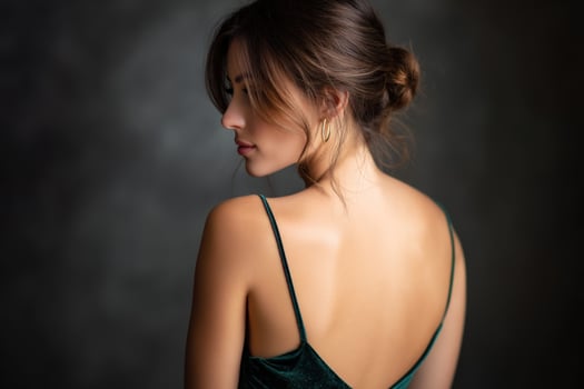 Woman with an elegant dress and updo hairstyle, looking away. Portraiture photo