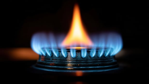 Gas burner with a mesmerizing blue and orange flame on a dark, sleek surface photo