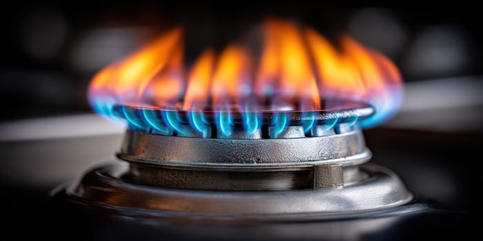 Blue flames dance on a metal gas burner, glowing with bright orange embers photo